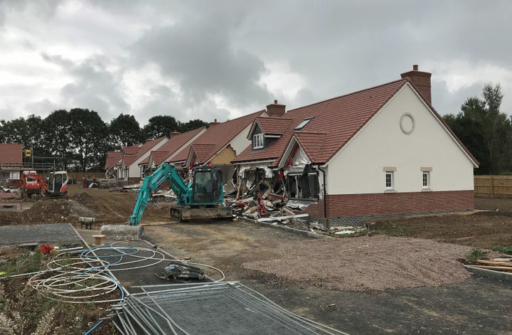 A digger remains stationary at the scene of the incident.