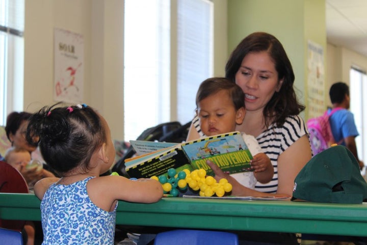 Mother, Elizabeth Paniagua, reads a board book with her 20-month-old son Joaquin, at Cesar Chavez Public Library located in the Fruitvale neighborhood in Oakland, California.