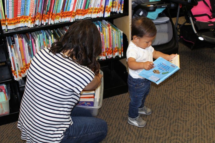 <p>Elizabeth Paniagua and her son Joaquin look for new books to check out from the local library. Cesar Chavez Public Library in Oakland Calif., also provides parents with toys as a checkout option.</p>