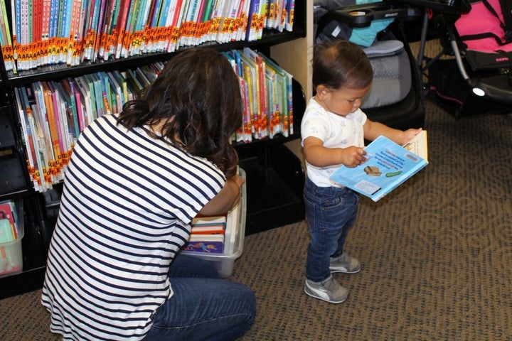 Elizabeth Paniagua and her son Joaquin look for new books to check out from the local library. Cesar Chavez Public Library in Oakland Calif., also provides parents with toys as a checkout option.