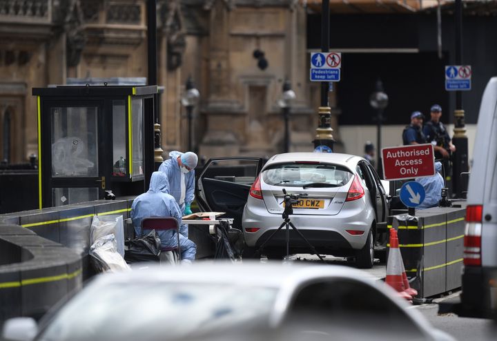 Forensic officers by the car that crashed into security barriers outside the Houses of Parliament, Westminster, London