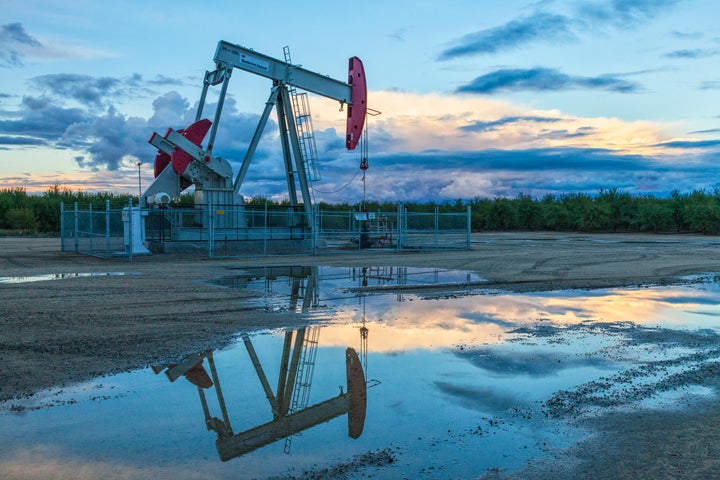 A pump jack and surface water at oil well and fracking site in California's San Joaquin Valley.