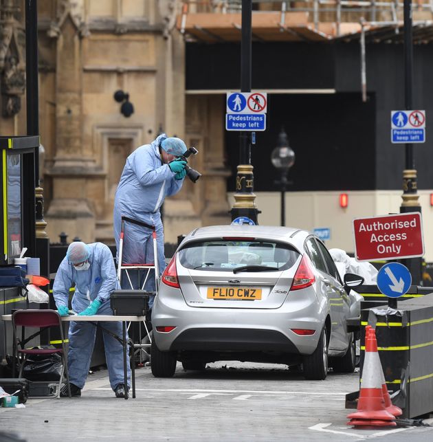 Forensic officers by the car that crashed into security barriers