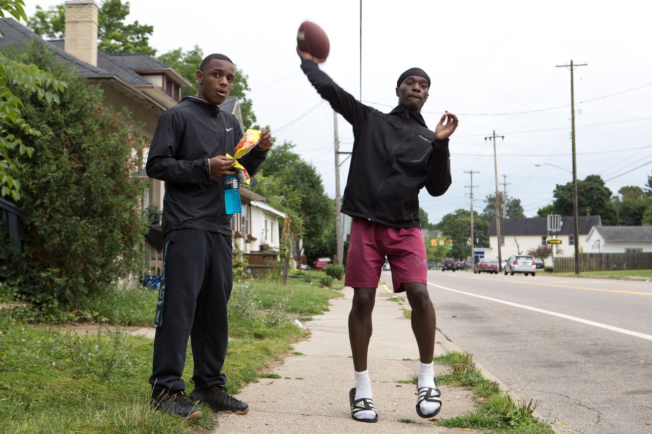Jones tosses a football while hanging out with his friends in front of his home.
