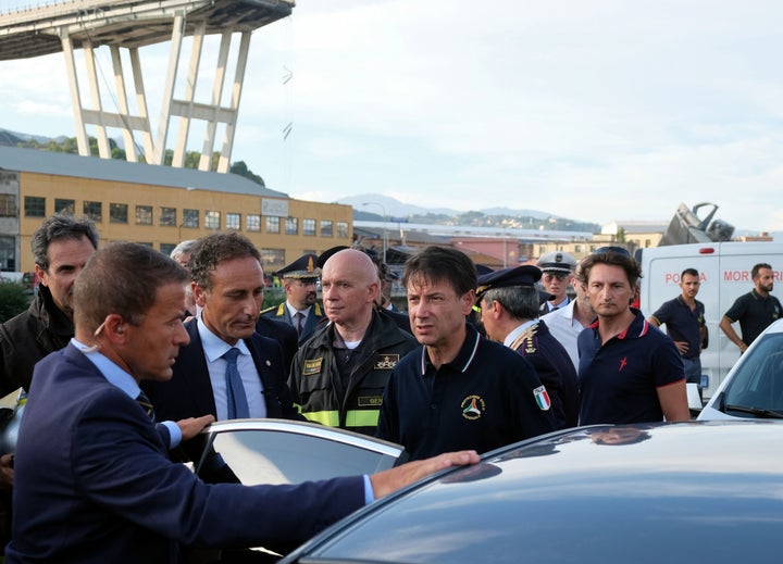 Italian Prime Minister Giuseppe Conte (center) visits the site after a section of the Morandi motorway bridge collapsed earlier in Genoa.