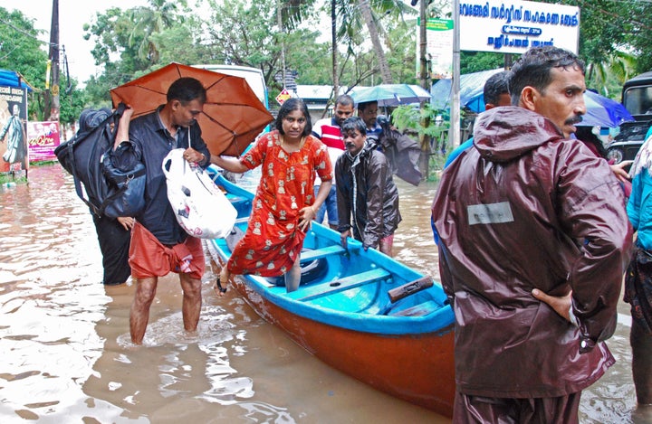 Indian volunteers and rescue personnel evacuate local residents in a boat in a residential area at Kozhikode, in the Indian s