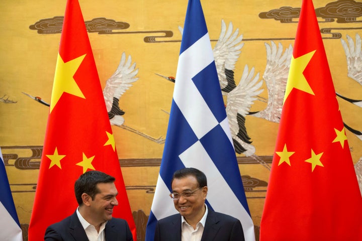 Chinese Premier Li Keqiang (R) chats with Greek Prime Minister Alexis Tsipras (L) during a signing ceremony held at the Great