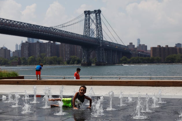 A child cools off from the hot weather at Domino Park in the Williamsburg section of