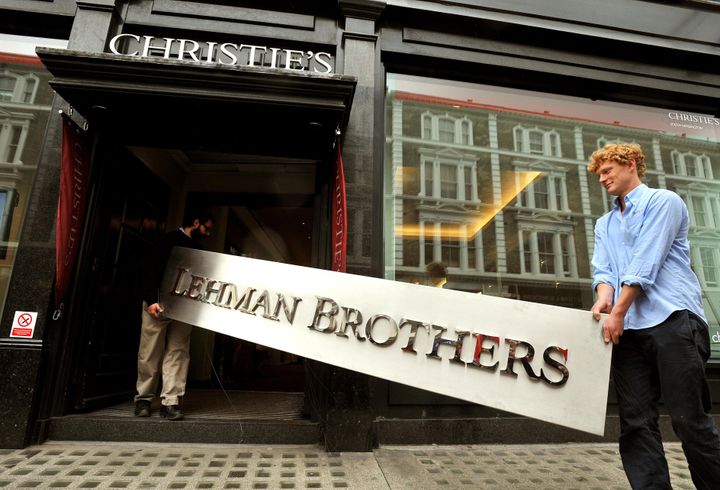Christie's employees walk into the auction rooms with the main sign from the Lehman Brothers London office after the bank collapsed.