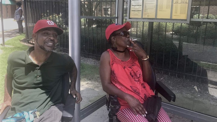 Larry Curry, left, and Delores Hall, right, light up outside the Barge Highrise senior housing complex in Atlanta, Georgia. A