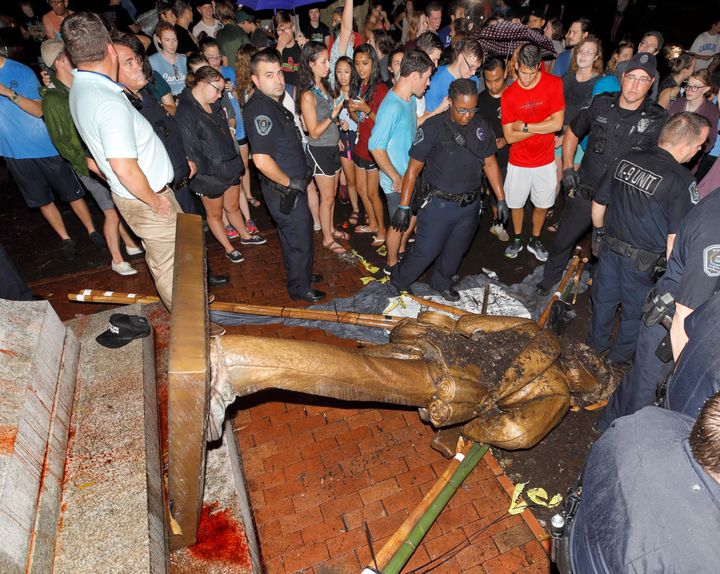 Police and protesters surround the toppled statue of a Confederate soldier nicknamed Silent Sam on the University of North Carolina campus in Chapel Hill. 