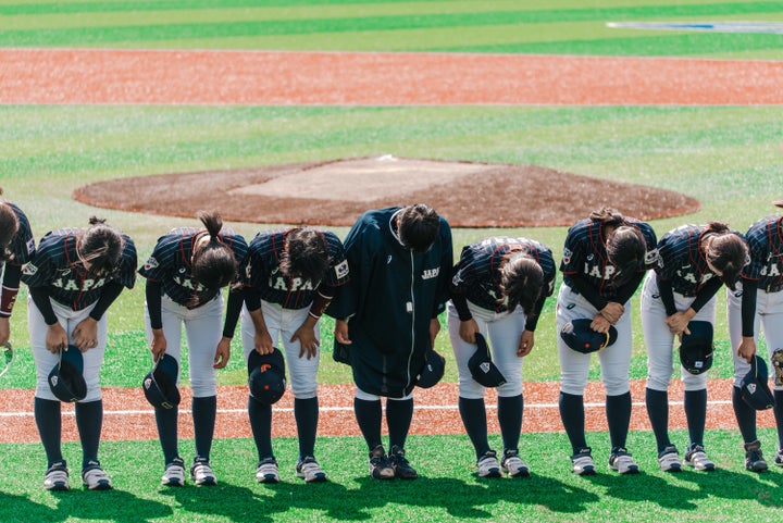 Team Japan bows during a game against Hong Kong at the Women's Baseball World Cup.