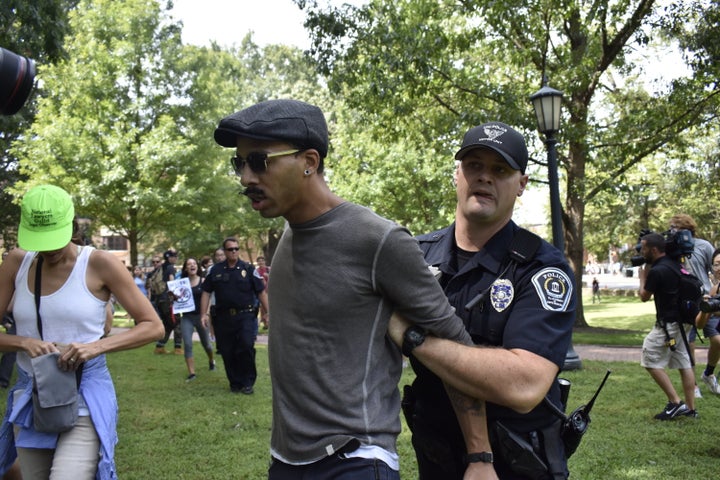 An unidentified man is arrested Aug. 25 after taking a Confederate flag from pro-Confederate demonstrator Paul Kin and stompi