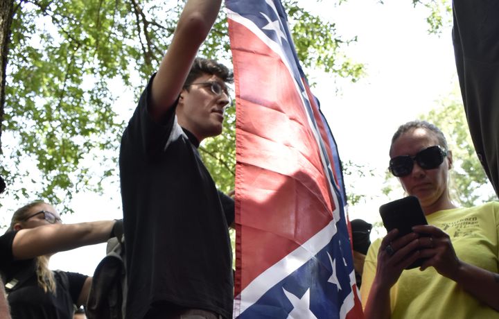 A man who identified himself as Paul Kin holds up a Confederate flag during a rally at the University of North Carolina, Chapel Hill on Aug. 25. (Courtesy of The Daily Tar Heel)