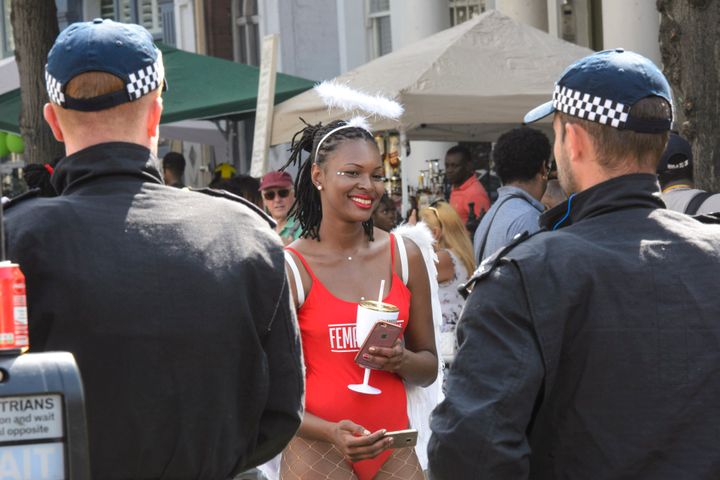 Revellers and police on the parade route during the Notting Hill carnival in west London