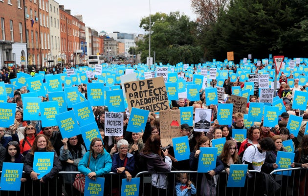 People hold placards as they take part in a protest during the visit of Pope Francis to Dublin.