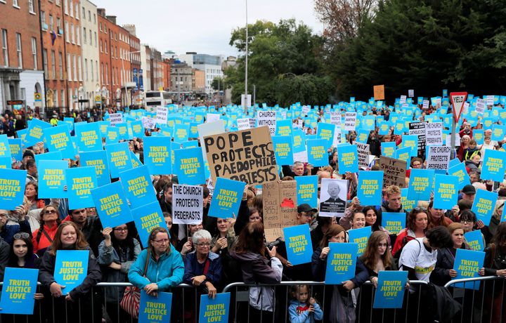 People hold placards as they take part in a protest during the visit of Pope Francis to Dublin.