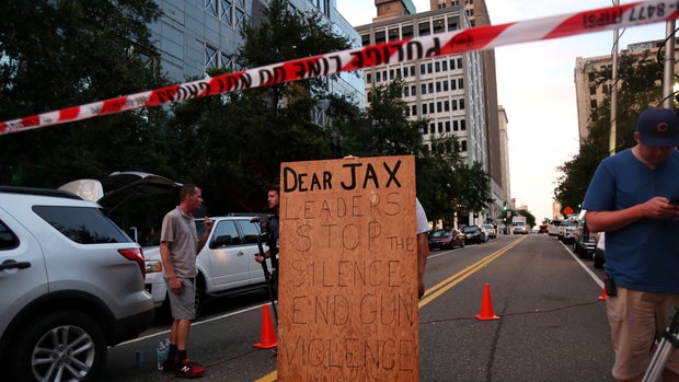 A man holds a sign in support of gun control outside of The Jacksonville Landing after a shooting in Jacksonville, Florida August 26, 2018.  REUTERS/Joey Roulette