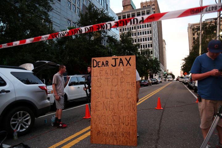 A man holds a sign in support of gun control outside of The Jacksonville Landing after a shooting in Jacksonville, Florida August 26, 2018
