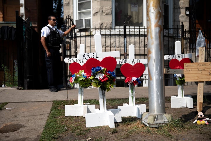 Wood crosses hold victims' names at the scene of a fire that killed at least eight people, including six children, on Sunday,