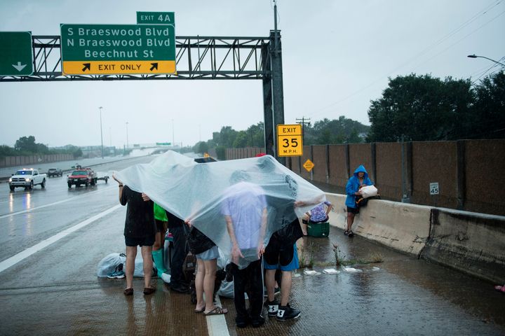 Residents of the Houston neighborhood of Meyerland wait on an I-610 overpass for help during the aftermath of Hurricane Harvey on August 27, 2017. 