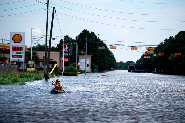 A woman paddles down a flooded road while shuttling deliveries for her neighbors during the aftermath of Hurricane Harvey on August 30, 2017 in Houston, Texas. 