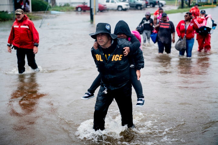 People walk to a Harris County Sheriff air boat while escaping a flooded neighborhood during the aftermath of Hurricane Harve