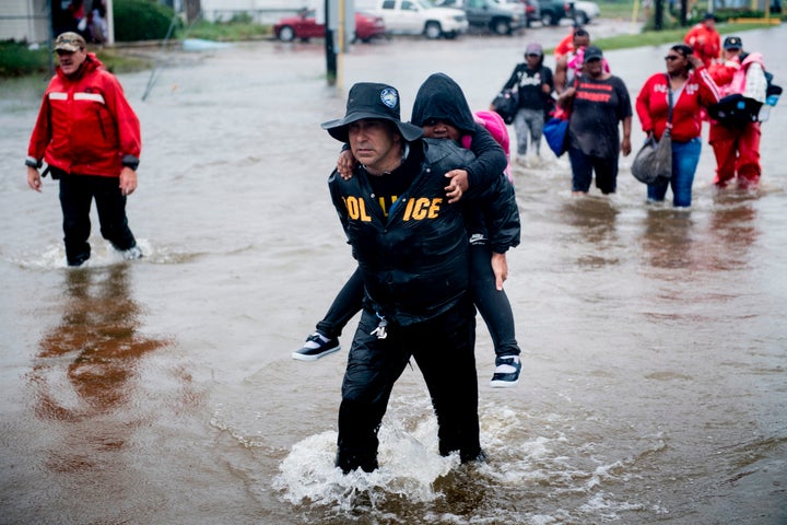 People walk to a Harris County Sheriff air boat while escaping a flooded neighborhood during the aftermath of Hurricane Harvey on August 29, 2017 in Houston, Texas. 