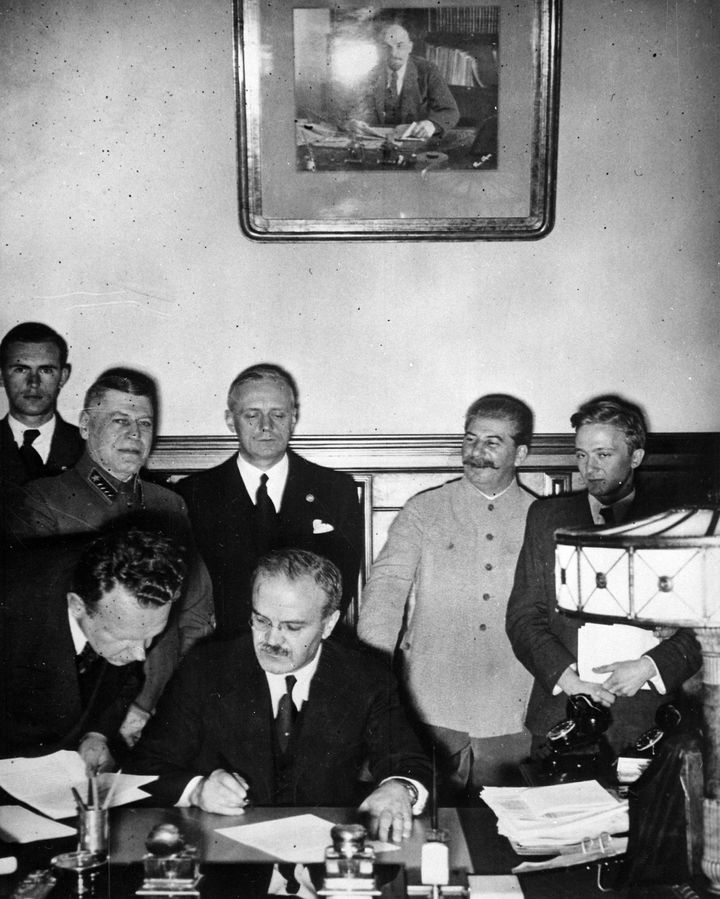 Russian Foreign Minister Vyacheslav Molotov signing the German-Soviet non-aggression pact, Moscow, Russia, 1939. German Minister Von Ribbentrop and Josef Stalin look on