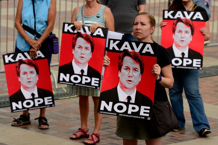 Claire Caruana holds up a sign during a rally to protest Kavanaugh's nomination at Civic Center Park in Denver on Aug. 26.