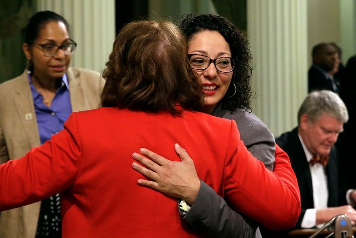Assemblywoman Cristina Garcia, D-Bell Gardens, right, is embraced by Assemblywoman Eloise Gomez Reyes, D-Grand Terrace, on her first day back at the Assembly in Sacramento, Calif. Until the new process is in place, people who brought complaints in the wake of #MeToo are still going through an old process that has prompted concerns.