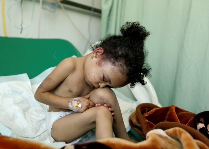 Buthaina Muhammad Mansour, believed to be 4 or 5, sits on a bed at a hospital after she survived a Saudi-led airstrike that k