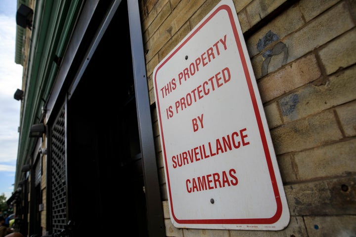 Surveillance signage is displayed on a door to the Cayuga Center in East Harlem, New York City.