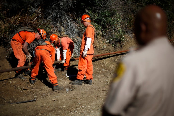 Prison inmates lay water pipe on a work project outside Oak Glen Conservation Fire Camp #35 in Yucaipa, California, on Nov. 6, 2014.