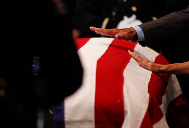 Mourners touch the casket during the memorial service.