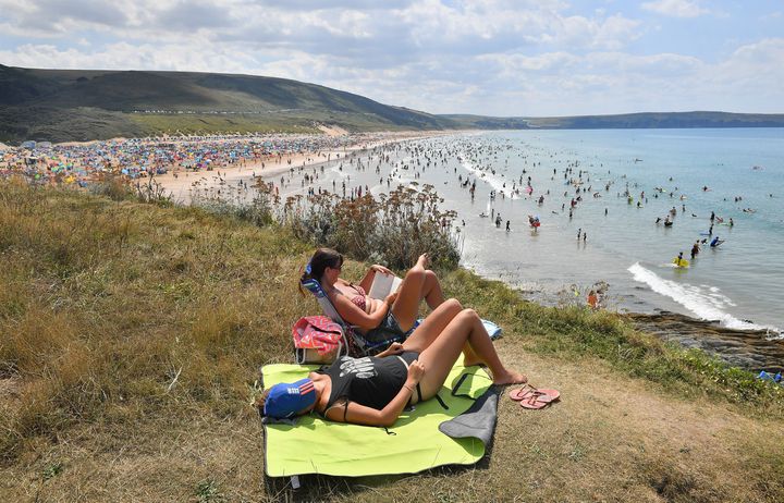 People sunbathe on the clifftop at Woolacombe Beach in North Devon