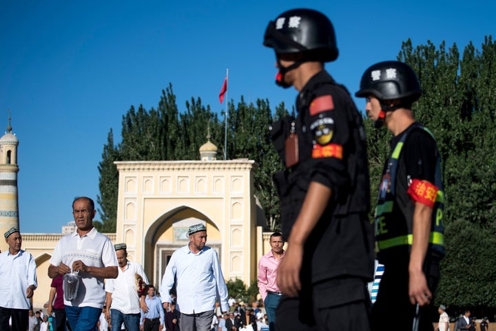 Police patrol as Muslims leave the Id Kah Mosque in June 2017 in the old town of Kashgar in China's Xinjiang Uighur Autonomous Region. The increasingly strict curbs imposed on the mostly Muslim Uighur population have stifled life in the tense Xinjiang region, where beards are partially banned and no one is allowed to pray in public.