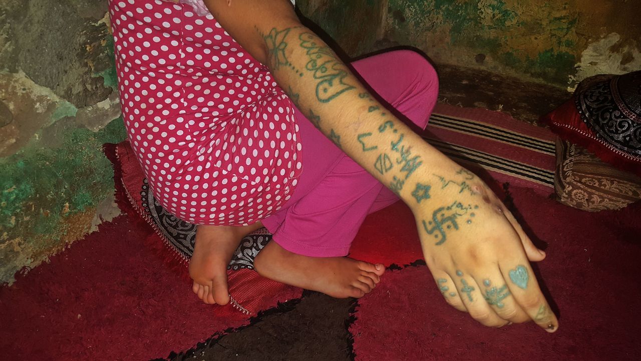 Teenager Khadija shows tattoos as she sits in the village of Oulad Ayad, in the Beni Mellal region of Morocco.