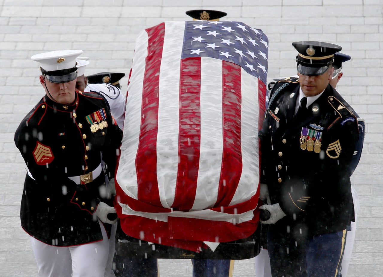 A military honor guard team carries the casket of the late senator into the Capitol.