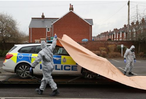 A police car being taken away by military personnel