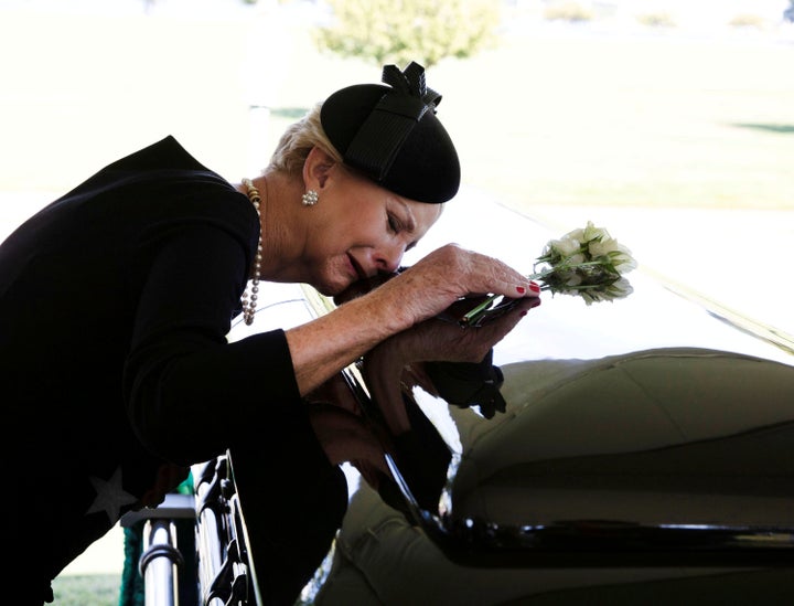 Cindy McCain lays her head on the casket of Sen. John McCain during a burial service at the cemetery at the United States Naval Academy in Annapolis, Md., on Sunday, Sept. 2.
