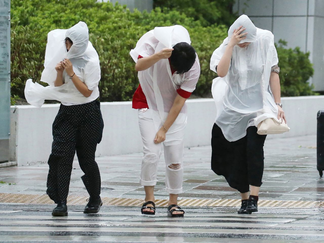 People walk against strong winds in Nagoya, Japan.