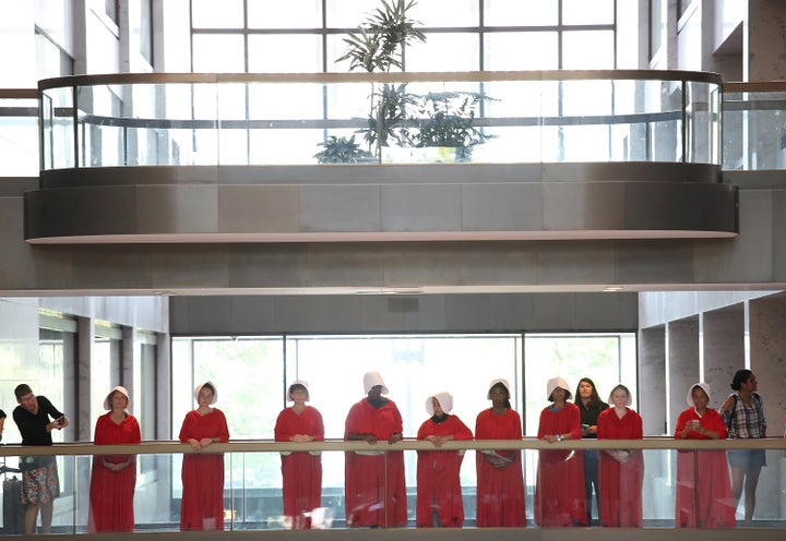 Protesters dressed in "The Handmaid's Tale" costumes stand outside the hearing room where Supreme Court nominee Judge Brett Kavanaugh will testify before the Senate Judiciary Committee during his Supreme Court confirmation hearing.