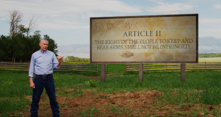 Matt Rosendale poses with a sign that says "Article II" while referencing the Second Amendment. 