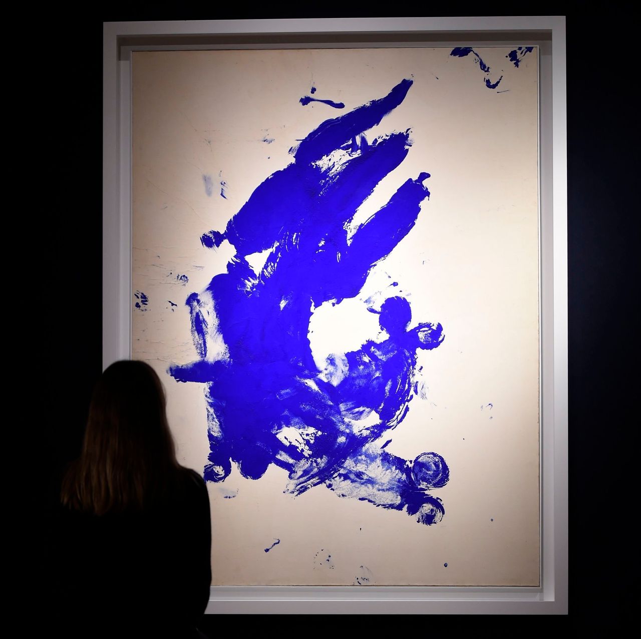 A woman looks at "Anthropometrie sans titre (Untitled Anthropometry)" by Yves Klein at Christie's in London.