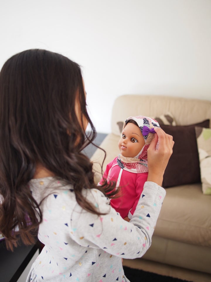 A young girl plays with a Salam Sisters doll named Maryam.