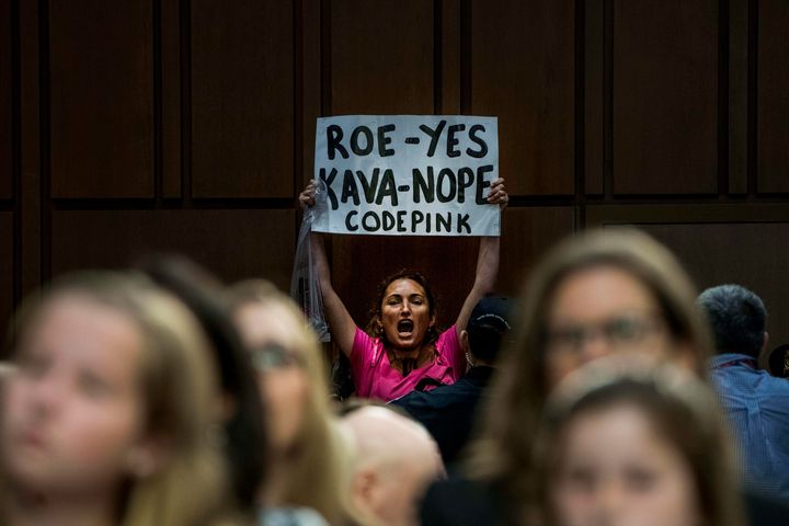 A woman holds up a sign in protest on Tuesday during the Senate confirmation hearing for Brett Kavanaugh.