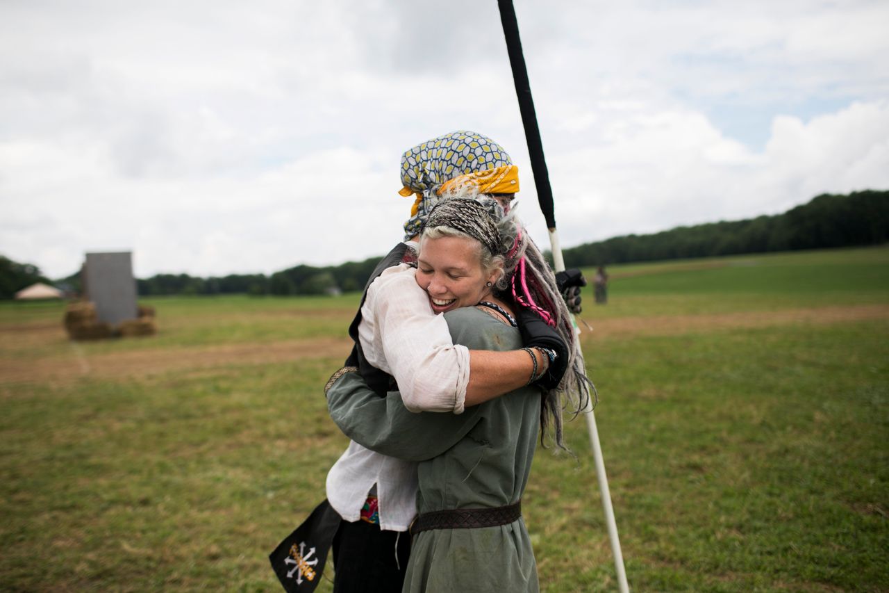Attendees hug on the field while training for battle. 