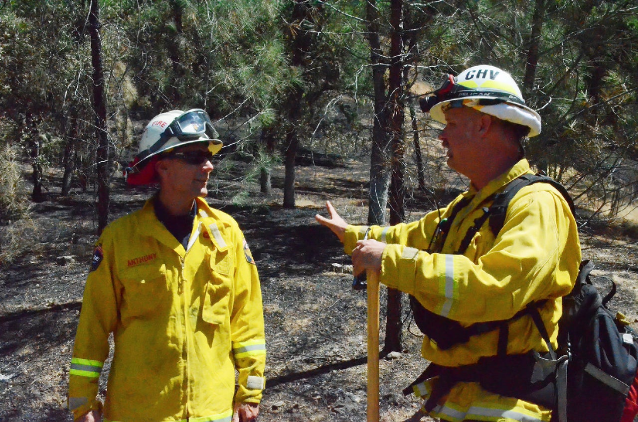 Cal Fire Division Chief Chris Anthony and David Albright, a battalion chief at the Chula Vista Fire Department, visit June 27 on a charred hillside in the Lake County community of Spring Valley, where multiple homes were destroyed by the Pawnee fire.