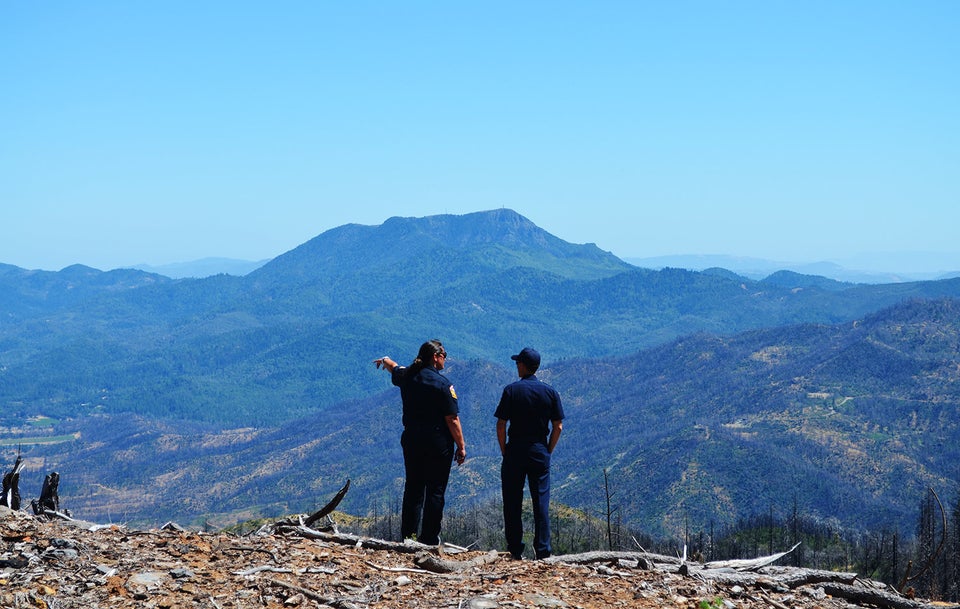 Emily Smith and Chris Anthony, both of Cal Fire, overlook a fire-scarred mountainside in Lake County,